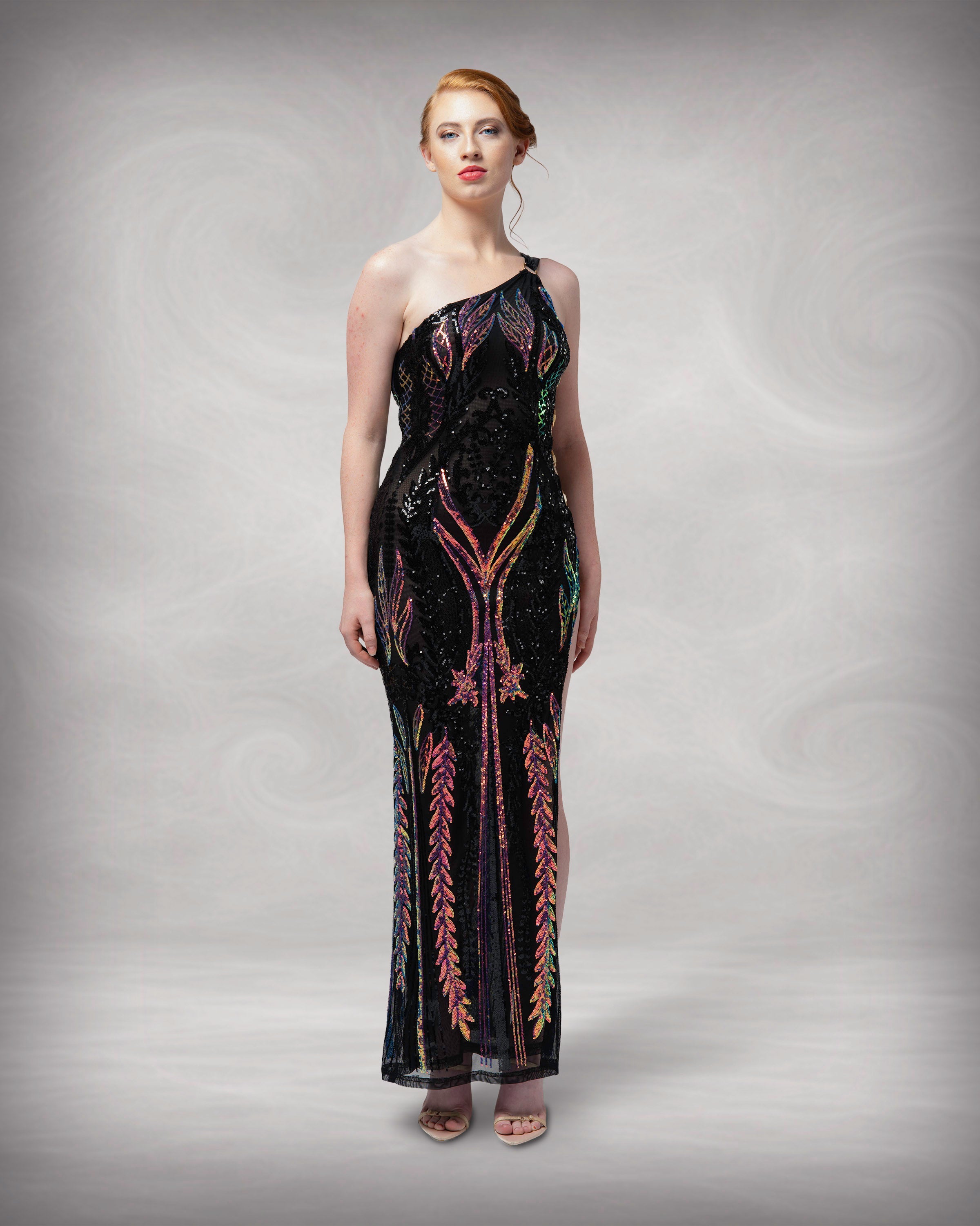 Woman wearing a black evening gown with gold detailing against a neutral background [color_id:black]