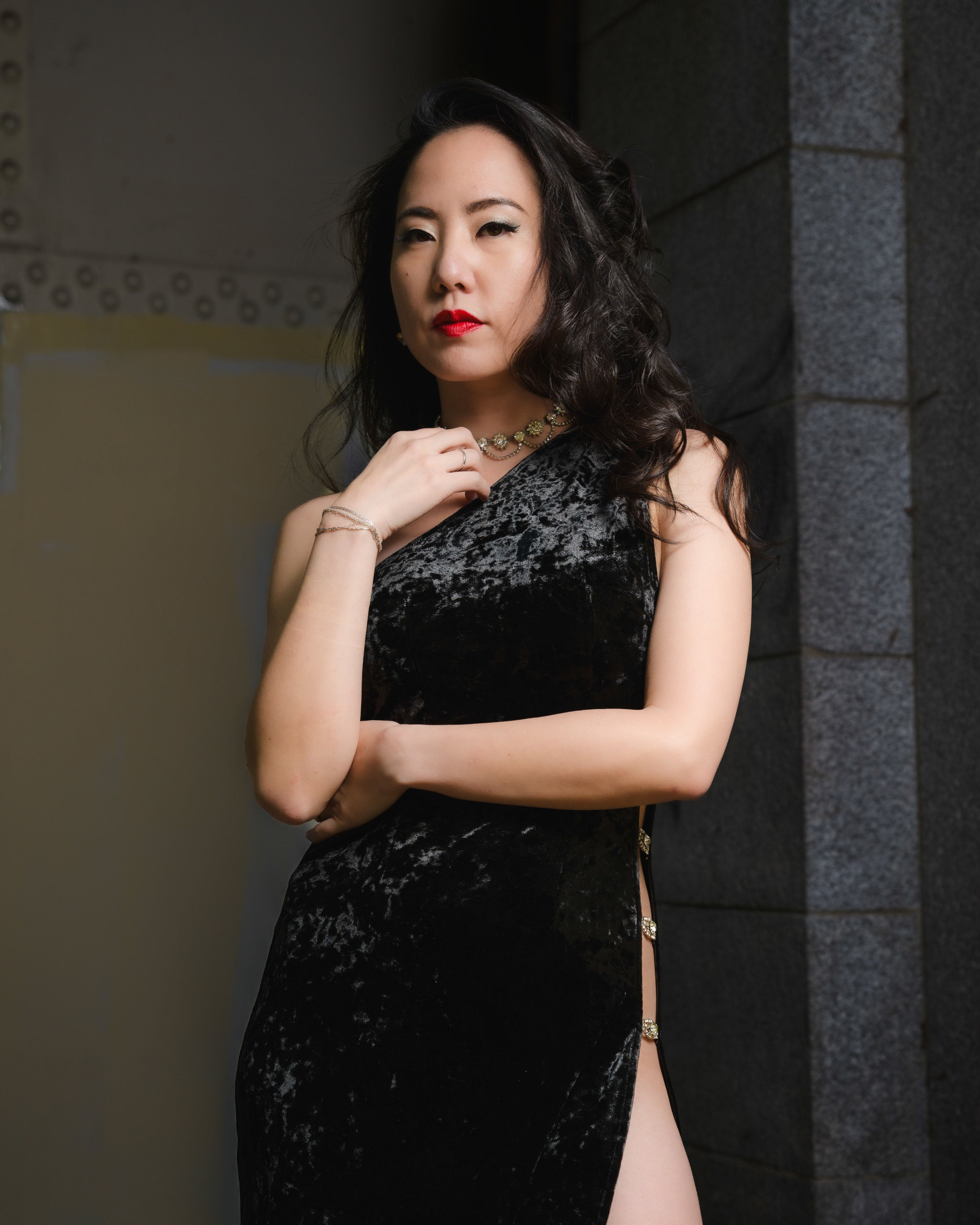 Woman in a black sequined dress posing against a dark background [model_size:XS] 