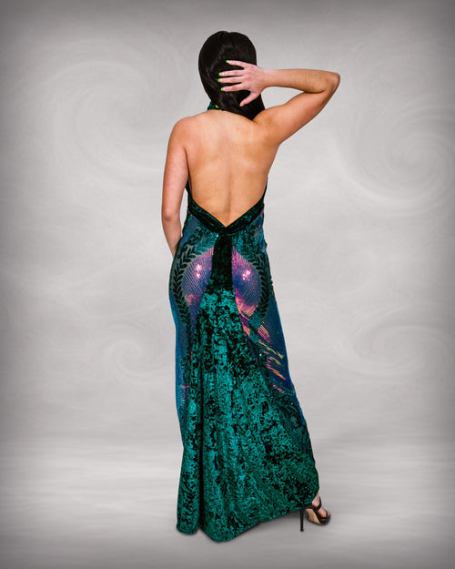 Woman wearing a green sequin evening gown with a backless design on a gray background  [color_id: green-purple]