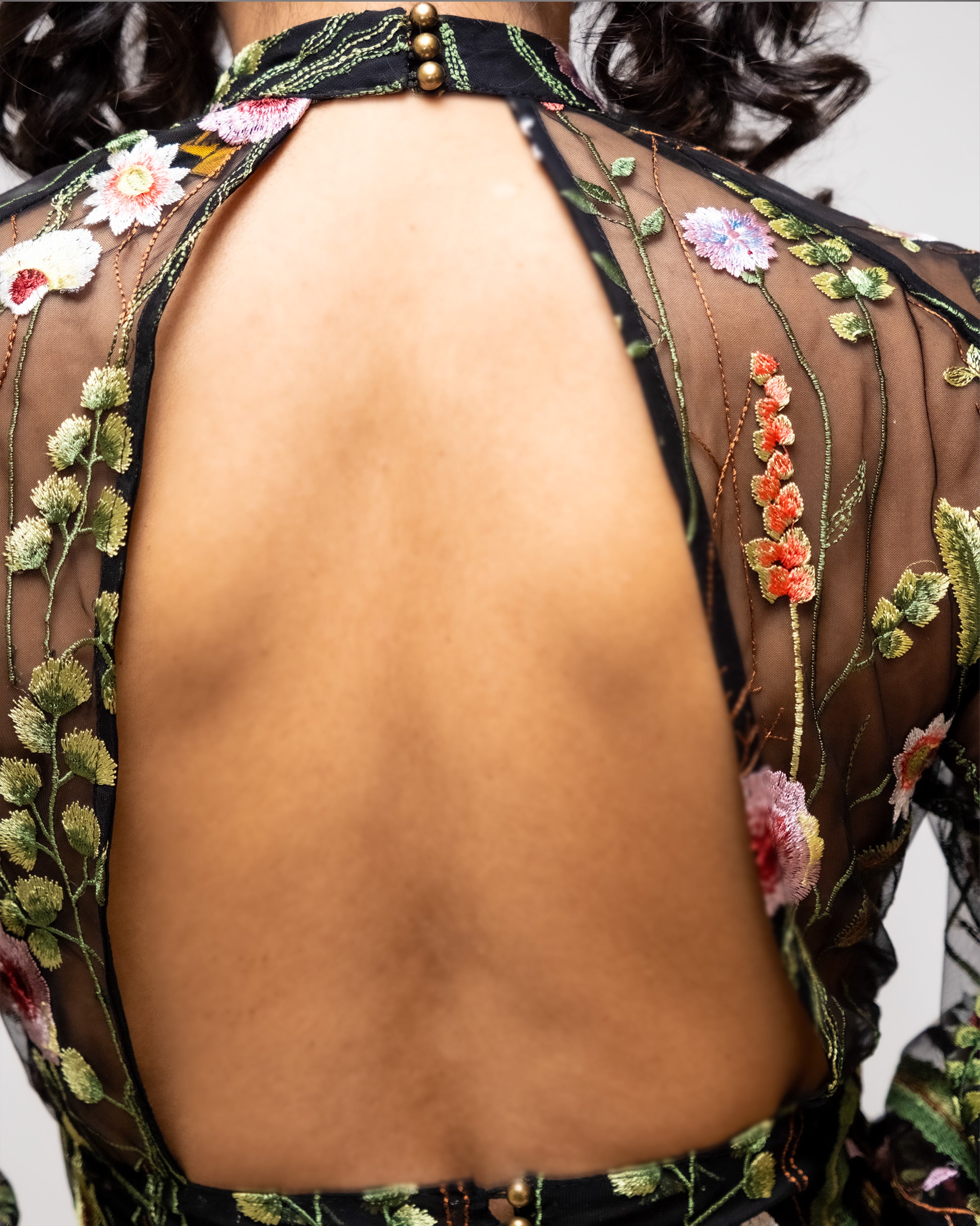 Back view of a garment with floral embroidery on a plain background [color_id:black]