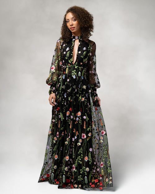 Woman wearing a black floral dress against a plain background [color_id:black]