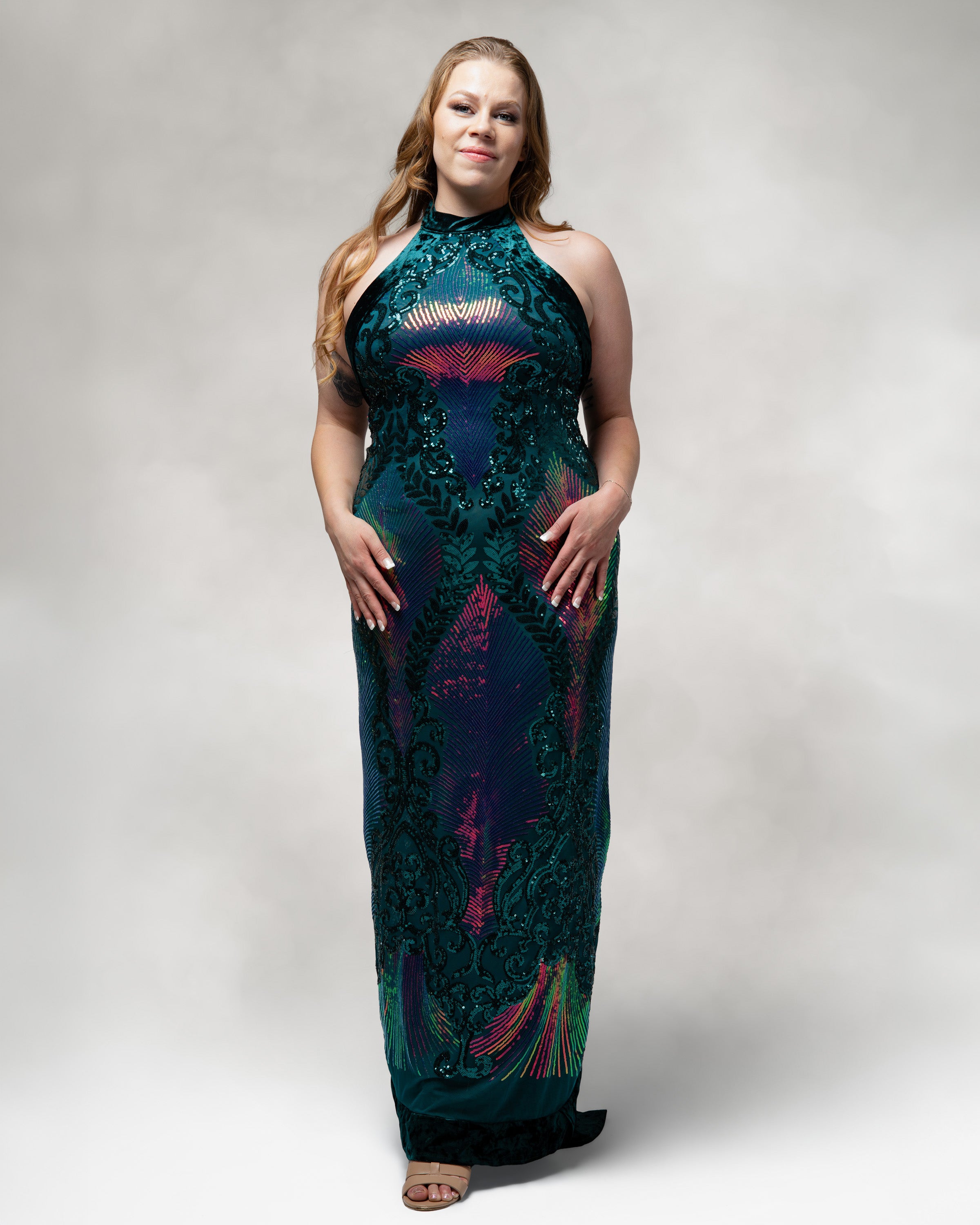 Woman wearing a long, patterned dress against a plain background [color_id: green-purple]