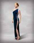 Woman wearing a blue one-shoulder dress with a high slit on a gray background [color_id:blue]
