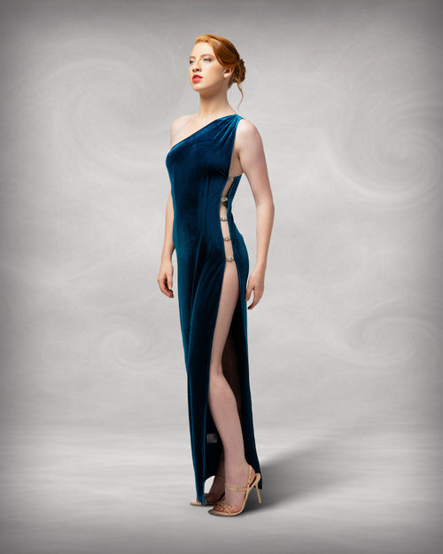 Woman wearing a blue one-shoulder dress with a high slit on a gray background [color_id:blue]